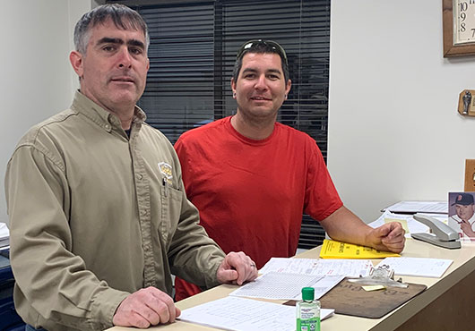 President John Cote Jr. (left) and Warehouse Director Phil Cote review incoming machinery documentation.